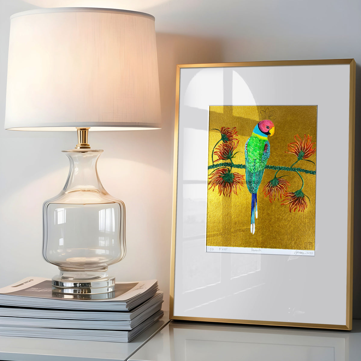 Devansh Limited Edition Hand Embellished Print on Paper in a gold frame on a table next to a lamp