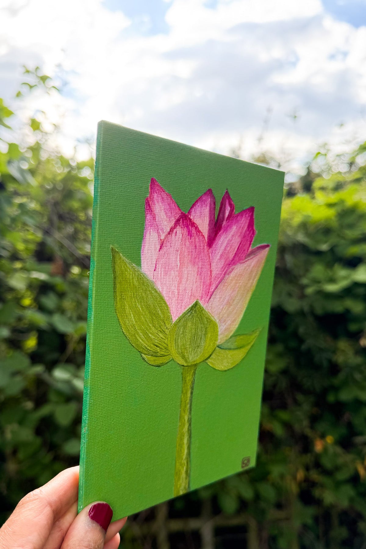 Side profile of a painting of a pink lotus flower and stem against a bright green background